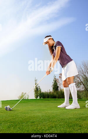 Golfeur féminin s'apprête à frapper la balle sur le terrain de golf Banque D'Images