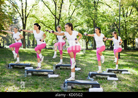 Un groupe de jeunes femmes de faire les exercices avec haltère sur une journée ensoleillée Banque D'Images
