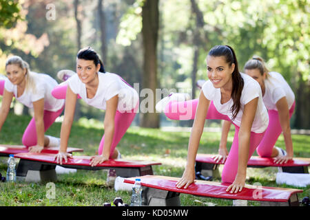 Groupe des femmes faire de l'exercice aérobique sur simulateurs Banque D'Images