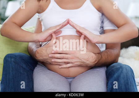 Futurs parents faire accueil en famille, femme enceinte estomac house concept Banque D'Images