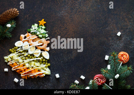 À partir de l'arbre de Noël une salade olivier sur un fond de pierre ou de métal rouillé. Vue de dessus avec une copie. Banque D'Images