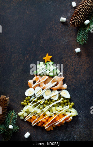 À partir de l'arbre de Noël une salade olivier sur un fond de pierre ou de métal rouillé. Vue de dessus avec une copie. Banque D'Images