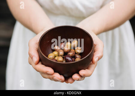 Woman holding bowl of olives, mid section Banque D'Images