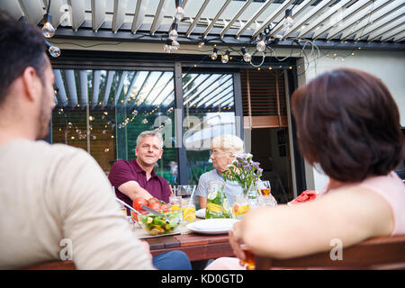 Plus d'épaule de hauts femme et homme mûr au déjeuner de la famille on patio Banque D'Images