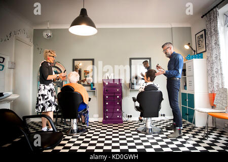 Vêtements vintage couple en travaillant sur des clients dans un salon de coiffure excentrique Banque D'Images