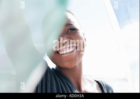 Portrait of young woman on beach, smiling, foulard dentelle holding