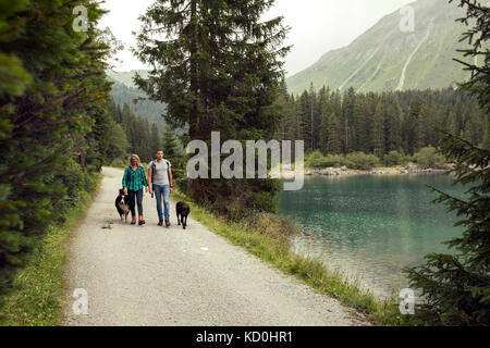 Couple avec chiens randonnées par lac, Tirol, Autriche, Europe Banque D'Images