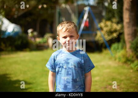 Portrait of cute boy standing in garden Banque D'Images