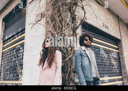 Portrait de jeune homme et femme, debout sur coin de rue, low angle view Banque D'Images