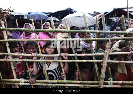 Teknaff, au Bangladesh. 8 oct, 2017. peuple Rohingya attend pour l'aide alimentaire au cours de la pluie à l'palongngkhali teknaff au camp de fortune, le Bangladesh le 08 octobre, 2017.Le Bangladesh a déclaré que ce serait l'un des plus gros de la came de réfugiés pour accueillir tous les 800 000 Rohingyas plus Musulmans qui ont demandé l'asile de la violence au Myanmar. crédit : zakir Hossain Chowdhury/zuma/Alamy fil live news Banque D'Images