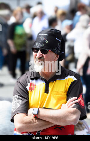 Portrait d'un homme âgé, les bras croisés et le port de couvre-chef, lunettes de soleil et un goatie blanc Banque D'Images