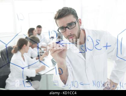 De derrière la vitre.scientist écrit un marqueur sur un bord de verre. Banque D'Images