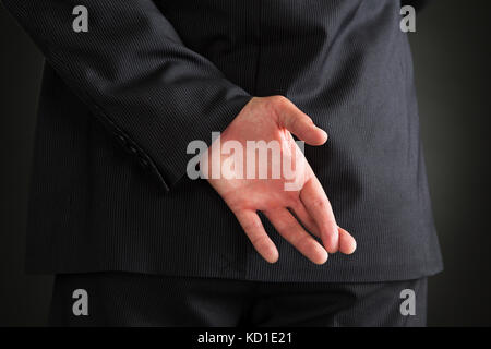 Vue arrière du businessman standing sur fond noir Banque D'Images