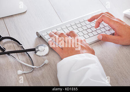 Les hommes de main du médecin de la saisie sur clavier d'ordinateur Banque D'Images