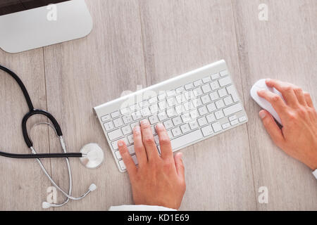 Les hommes de main du médecin de la saisie sur clavier d'ordinateur Banque D'Images