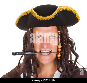 Tenue de pirate couteau dans sa bouche sur fond blanc Banque D'Images