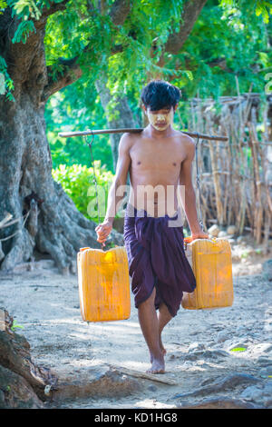 Fermier birman transportant des seaux remplis d'eau dans un village près de Bagan Banque D'Images