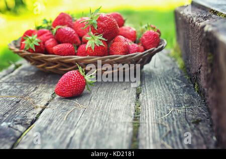 La fraise au plaque d'osier sur fond de bois Banque D'Images