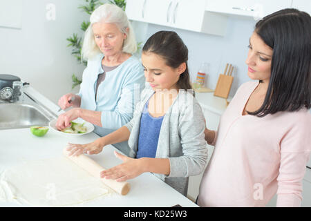 Trois générations famille apprécié la cuisson dans la cuisine Banque D'Images