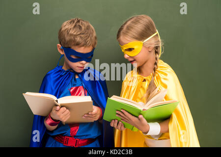 Les élèves de superhero costumes avec books Banque D'Images