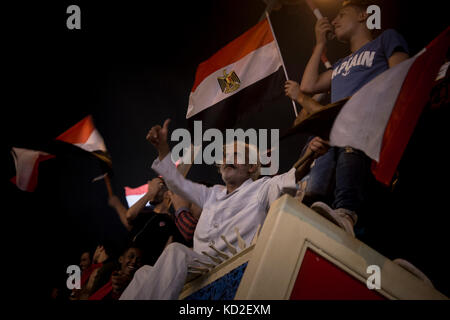 Le Caire, Égypte. 08 octobre 2017. Les Égyptiens brandissent des drapeaux nationaux alors qu'ils se rassemblent sur la place Tahrir pour célébrer la qualification de leur équipe nationale de football pour la Coupe du monde FIFA 2018 pour la première fois en 28 ans après avoir battu la République du Congo 2-0 lors de leur match de qualification pour la Coupe du monde FIFA 2018, au Caire, en Égypte, le 8 octobre 2017. Crédit : Gehad Hamdy/dpa/Alamy Live News Banque D'Images