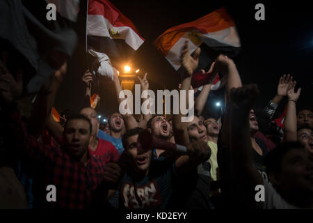 Le Caire, Égypte. 08 octobre 2017. Les Égyptiens brandissent des drapeaux nationaux alors qu'ils se rassemblent sur la place Tahrir pour célébrer la qualification de leur équipe nationale de football pour la Coupe du monde FIFA 2018 pour la première fois en 28 ans après avoir battu la République du Congo 2-0 lors de leur match de qualification pour la Coupe du monde FIFA 2018, au Caire, en Égypte, le 8 octobre 2017. Crédit : Gehad Hamdy/dpa/Alamy Live News Banque D'Images