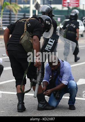 Une photojournaliste Sri lanka attaché les lacets des policiers au cours d'une manifestation mars exhorte le gouvernement à garantir les droits à l'éducation, à Colombo, Sri Lanka le 10 octobre 2017 Credit : lahiru harshana/Alamy live news Banque D'Images