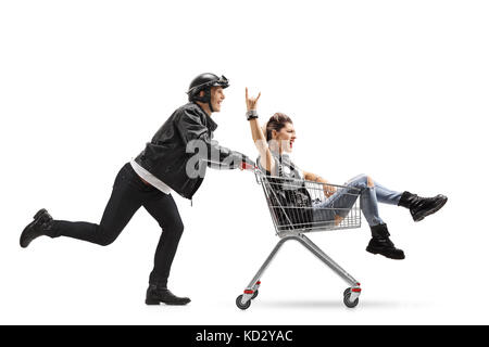 Biker pousser un panier avec un punk girl riding à l'intérieur et en faisant un signe de rock isolé sur fond blanc Banque D'Images