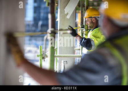 Les travailleurs de la construction du bâtiment de mesure Banque D'Images