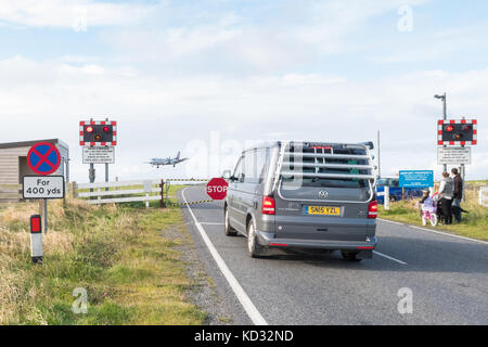 Aéroport de Sumburgh - avion arrivant sur une piste qui est traversée par une route contrôlée par un passage à niveau, Shetland Islands, Écosse, Royaume-Uni Banque D'Images