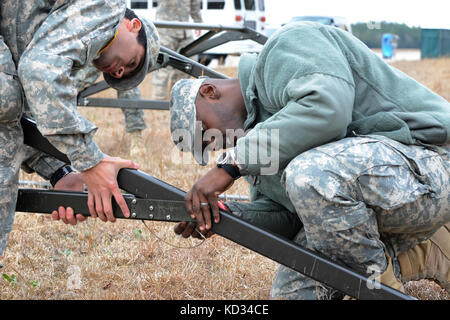 Pvt. Armée américaine Demetrius Fuel, analyste d'intel, et Pvt. Peter Brost, spécialiste en technologie de l'information, tous deux affectés au siège social et à la compagnie 2151 du siège social de la Garde nationale de l'Armée de Caroline du Sud, assemble une tente lors de l'exercice de la Garde vigilante le 6 mars 2015, à l'aéroport de Georgetown, S.C. vigilant Guard est une série d'exercices d'intervention en cas de catastrophe financés par le gouvernement fédéral et menés par des unités de la Garde nationale qui travaillent avec des organismes de gestion des urgences fédéraux, d'État et locaux et des premiers intervenants. (Photo de la Garde nationale aérienne par Airman 1ère classe Ashleigh S. Pavelek/publié) Banque D'Images