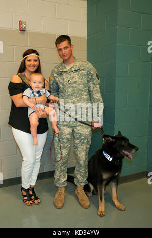 La CPS de l'armée américaine. brandon Meyer, un maître-chien militaire avec le 17e Détachement de la police militaire de Fort Jackson, accueille Segal, son chien de travail, à la suite d'une cérémonie de fin de cours de dirigeants le guerrier à l'mccrady centre de formation, eastover, s.c., 24 avril 2015. Meyer était l'un des 130 soldats qui est diplômé de la 3 semaines Cours wlc hébergé par 3e bataillon, sous-officiers academy sur mccrady. Meyer a été réuni avec sa femme ashley et leur fils aidan après la cérémonie, et Segal a été apporté par les membres de son unité. (Photo de la garde nationale américaine par tech. sgt. Jorge int Banque D'Images