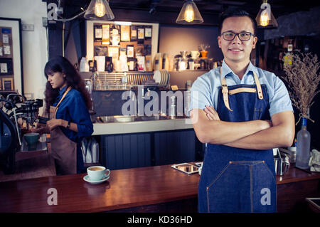 Portrait of smiling asian barista avec les bras croisés au comptoir à café. café restaurant service, propriétaire de petite entreprise, l'industrie alimentaire et des boissons Banque D'Images