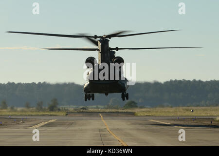 L'Armée américaine Un hélicoptère CH-47 Chinook de la Caroline du Sud la garde nationale 2-238e soutien général Aviation Battalion de Greenville, S.C., quitte à contribuer à la réparation de la Colombie-Britannique Canal en plaçant plus de 750 livres 1 000 sacs de sable dans la violation comme l'inondation continue SCNG opérations d'intervention de l'aviation de l'Armée de SCNG Support Facility à McEntire Joint National Guard Base, le 7 octobre 2015. La Garde nationale de Caroline du Sud a été activé à l'appui de l'état et les organismes de gestion des urgences du comté et les premiers intervenants locaux comme les impacts des inondations historiques à l'échelle des comtés. Curren Banque D'Images