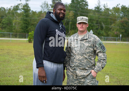 Clifton Geathers, joueur de la NFL, pose pour des photos avec des soldats de l'armée américaine affectés à la 1053e compagnie de transport, Garde nationale de l'armée de Caroline du Sud, pour vous remercier de les avoir aidés à récupérer leurs effets personnels de famille depuis leur domicile inondé à Brown's Ferry près de Georgetown, en Caroline du Sud, le 10 octobre 2015. La Garde nationale de Caroline du Sud a été activée pour soutenir les agences de gestion des urgences de l'État et du comté et les premiers intervenants locaux, car les inondations historiques affectent les comtés de l'État. Actuellement, plus de 3,000 membres de la Garde nationale de Caroline du Sud ont été activés en réponse aux inondations. ( Banque D'Images