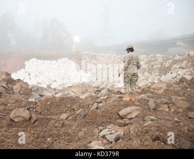 Un soldat de la garde nationale de Caroline du Nord, affecté à la 505ème bataillon du génie, examine le barrage temporaire créé par les ingénieurs et d'autres homologues civils, après les graves inondations qui ont endommagé un canal en Colombie-Britannique, s.c., oct. 14, 2015. l'ncng a été prêts à soutenir la division de la gestion de l'urgence de la Caroline du Sud et d'autres organismes partenaires fédéraux et d'État de Caroline du Sud se remet des effets de la chute de pluie prolongée, provoquant de graves inondations dans tout l'état. (U.s. Army National Guard photo par le sgt Brian godette, 382e détachement des affaires publiques/libérés) Banque D'Images