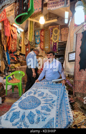 La province du Fars, Shiraz, Iran - 19 avril 2017 : le département des objets textiles dans la ville bazar, le vendeur iranien démontre ses marchandises. Banque D'Images