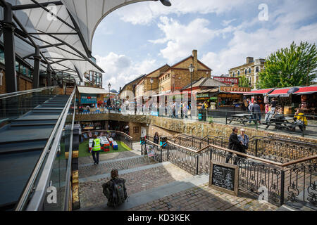 Photo grand angle de Camden Lock dans une journée ensoleillée avec des nuages, des arbres, des gens assis et monter les escaliers, à Londres. Banque D'Images