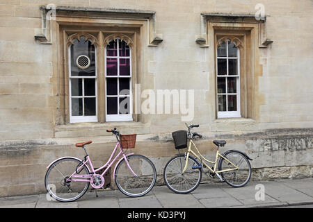 Mesdames bicyclettes appuyée sur mur de bâtiment College, Oxford, UK Banque D'Images