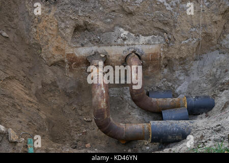 L'eau grand métal acier tuyaux pvc avec isolement en sol tranchée à ciel ouvert lors de fossé en construction Plomberie Réparation traiter Banque D'Images