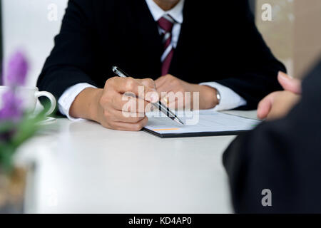 Patron séance à une œuvre nouvelle qui vient de passer l'entrevue d'emploi Banque D'Images