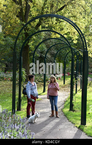 Deux femmes parlant dans un parc public et des jardins ensoleillés Grande-bretagne Uk Banque D'Images