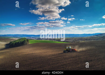 Cultiver du tracteur au champ du printemps, vue aérienne Banque D'Images