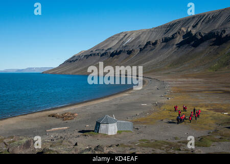 La Norvège, Svalbard, au sud de la réserve naturelle de Svalbard, edgeoya, kapp lee. ancien chalet des trappeurs sur la plage près de petit groupe de morses sur beach Banque D'Images