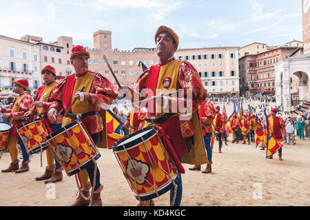 Les hommes avec des musiciens de la batterie dans des costumes colorés historiques célébrant à traditionnel palio course de chevaux à Sienne, il parade Banque D'Images