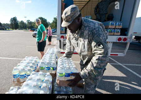 Sergent d'état-major de l'armée américaine John C. Williams, de la 742e compagnie de maintenance, de la Garde nationale de l'Armée de Caroline du Sud, distribue de l'eau potable aux résidents touchés par les inondations de Caroline du Sud à la Lower Richland High School, Columbia, Caroline du Sud, le 6 octobre 2015. La Garde nationale de Caroline du Sud a été activée pour soutenir les agences de gestion des urgences de l'État et du comté et les premiers intervenants locaux, car les inondations historiques affectent les comtés de l'État. Actuellement, plus de 1,100 membres de la Garde nationale de Caroline du Sud ont été activés en réponse aux inondations. (ÉTATS-UNIS Photo de la Garde nationale aérienne par Tech. Banque D'Images