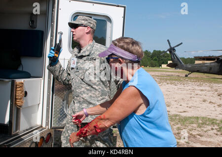 L.c soldat de la garde nationale le sergent wesley brantley, infirmier de 1er bataillon d'infanterie, 118e siège et l'appui du siège, aide quelqu'un dans les blessures simulées lors d'un exercice d'entraînement le 30 juin 2014, au centre de formation mccrady. Au cours de l'exercice, les organismes civils et militaires ont joint leurs forces pour répondre à une simulation d'avion écrasé. Ils ont été confrontés à une variété de blessures à partir de simples coupures et éraflures de graves blessures et même de décès qui serait obtenu si c'était un véritable scénario. Le but de l'exercice était d'évaluer les politiques, les procédures, l'équipement et le personnel tout en p Banque D'Images