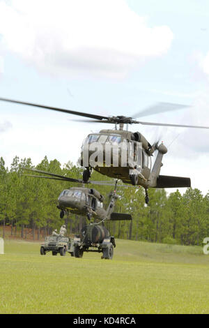 Les soldats de l'armée américaine du 351e Bataillon de soutien de l'aviation, Garde nationale de l'armée du Canada, ont accroché un humvee et un buffle d'eau à Black Hawks pour pratiquer des opérations de chargement de harnais à fort Jackson, le 13 juillet 2014. La formation fait partie de la préparation de l'unité à la mobilisation pour leur prochain déploiement au Koweït. (ÉTATS-UNIS Photo de la Garde nationale de l'armée par le Sgt. Brian Calhoun/publié) Banque D'Images