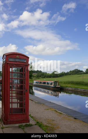 Le Leeds et Liverpool Canal à la marina du parc inférieur, Barnoldswick, Lancashire, England, UK : cabine téléphonique rouge sur le quai Banque D'Images