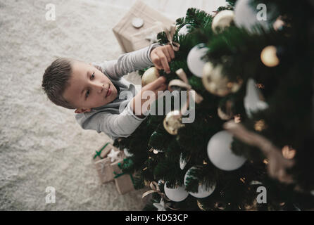 Boy decorating a Christmas Tree Banque D'Images